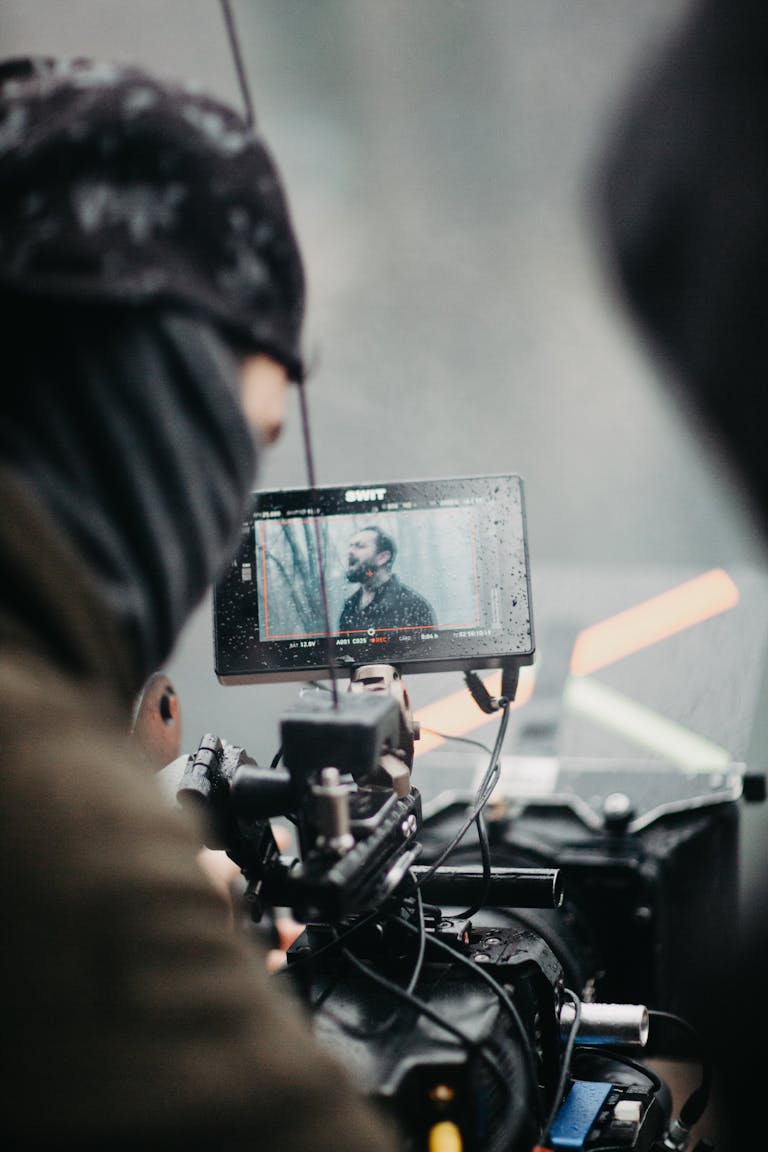 About 1 Film crew capturing footage on set with a professional camera and monitor.