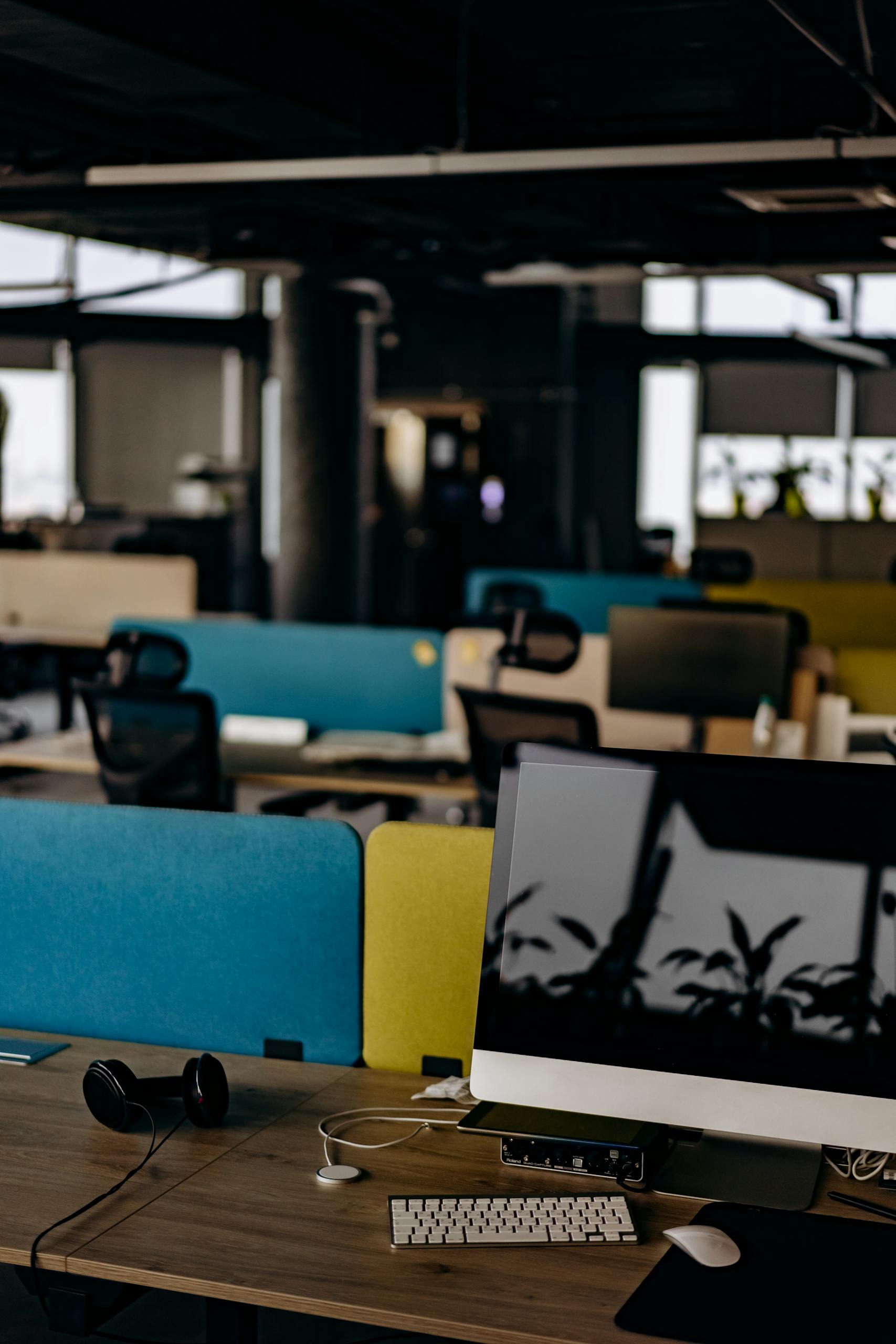 About 6 Open office space with computers and colorful partitions, perfect for modern work settings.